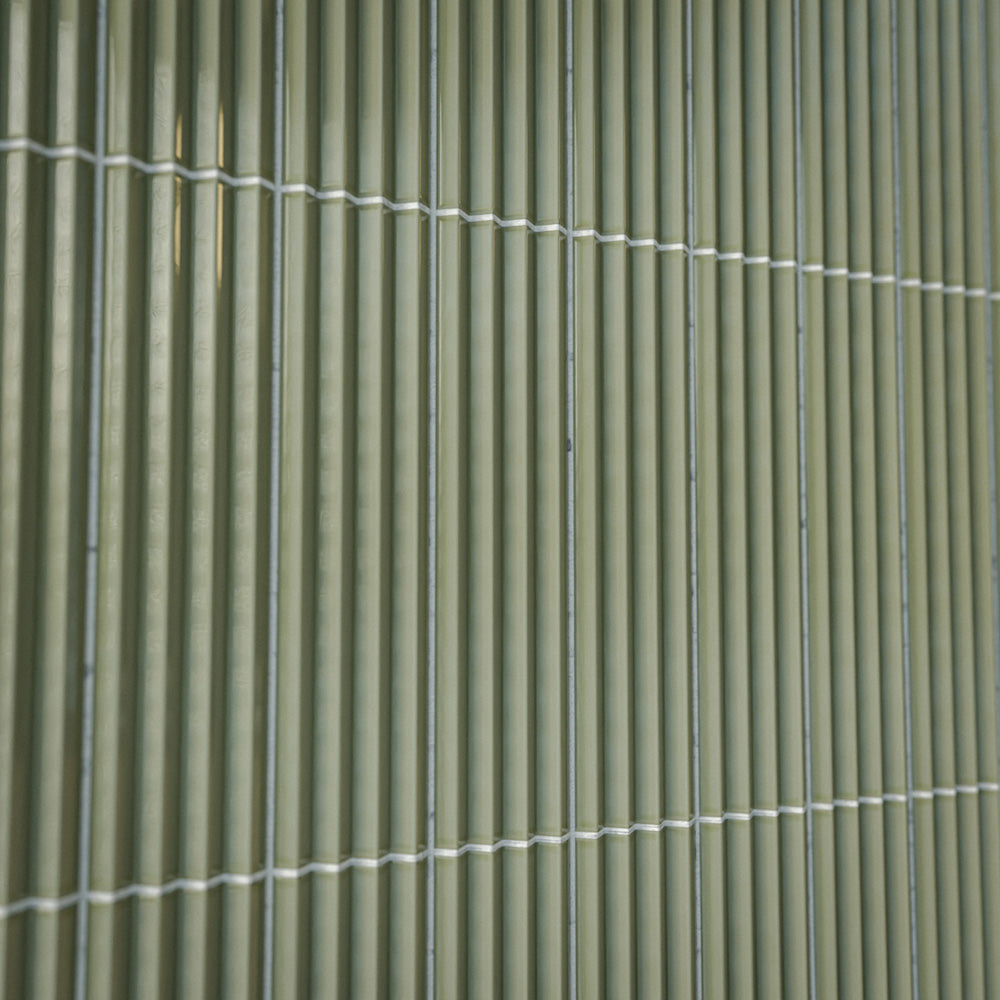 Close-up of Gallery 3D Fluted Decor Tansy Green Gloss 5cm x 20cm wall tiles, showcasing the raised fluted texture, soft green tone, glossy finish and subtle surface variation.