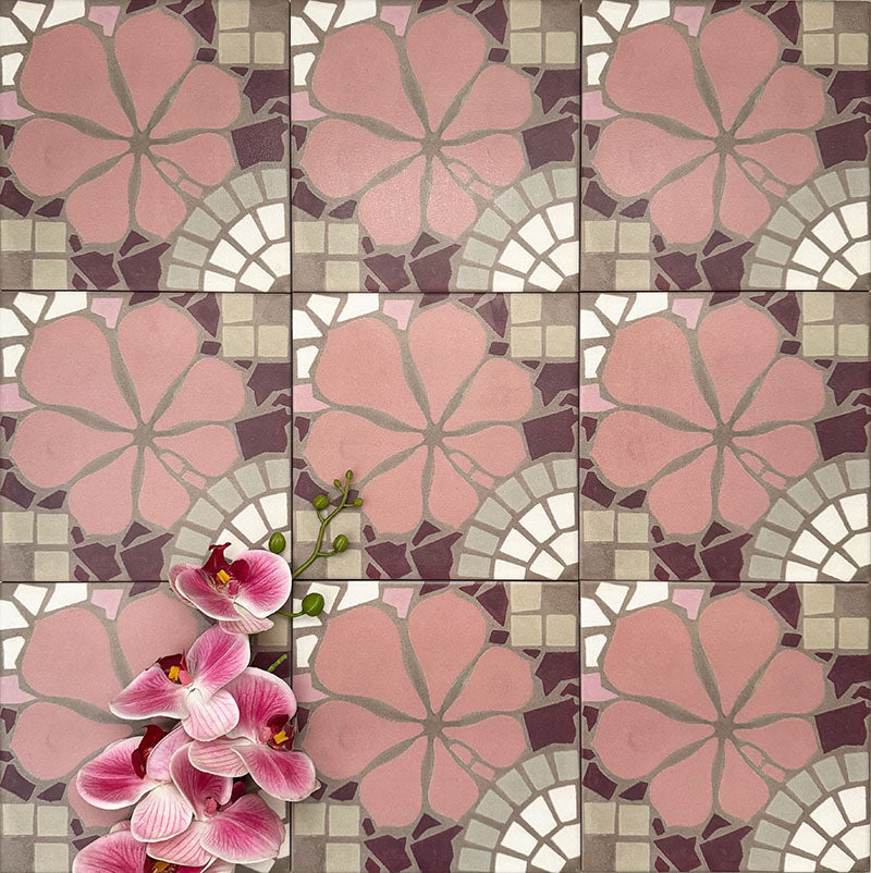 Nantes Rose Pink Moroccan-style tiles arranged in a repeating pattern, featuring soft pink floral motifs framed by mosaic-inspired geometric shapes in warm neutrals and deep burgundy tones. The 20x20cm patterned tiles are styled with pink flowers for scale and texture, highlighting their decorative encaustic-style design.