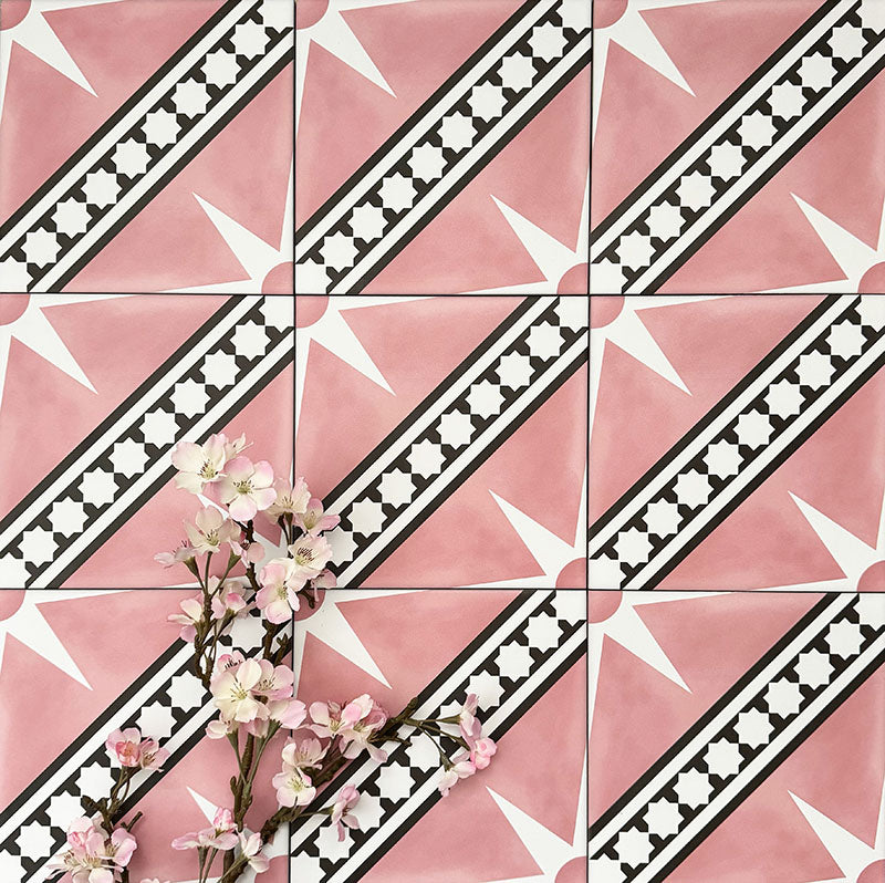 Gilgamesh Pink Moroccan style 20x20cm patterned tiles, shown in a flat lay with decorative foliage to highlight the geometric star design in soft pink, black and white.