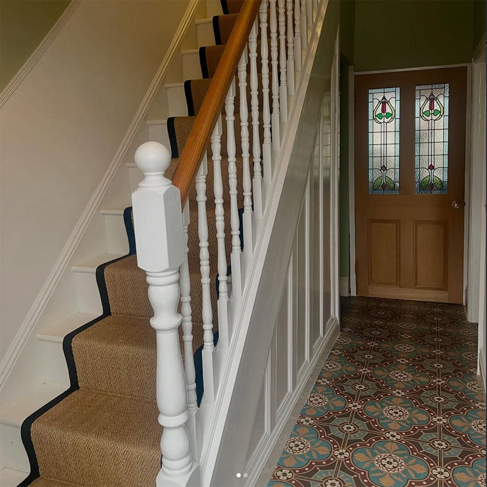 Hallway interior featuring London Streets Hanover Square 20x20cm Victorian Moroccan style floor tiles, styled with a traditional staircase, herringbone stair runner, white balustrade and stained glass front door for a classic entrance hallway.