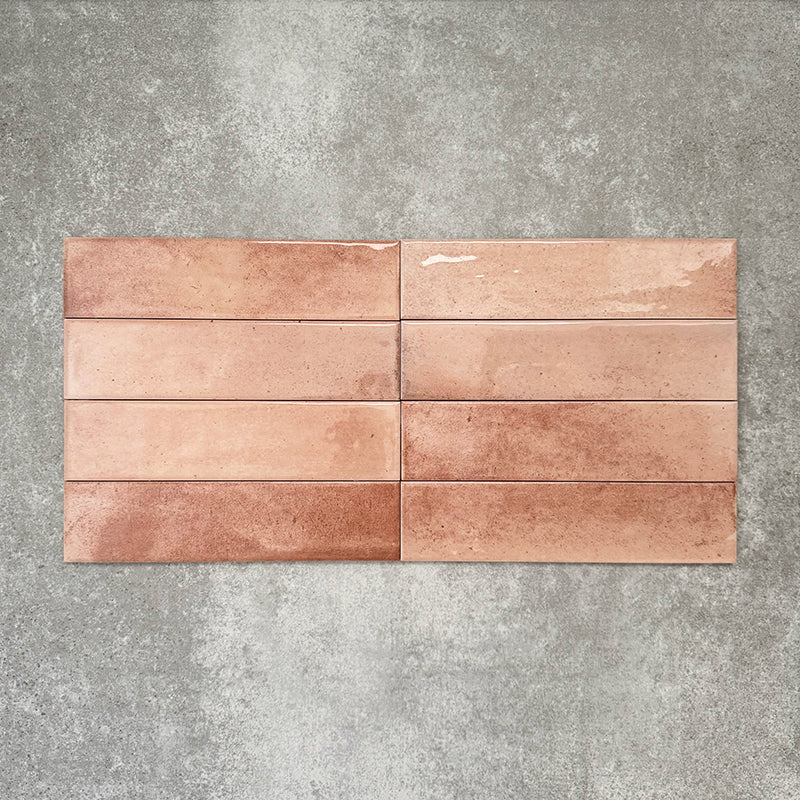 Allegra Tusk Pink Gloss Brick ceramic tiles in a 6 × 25cm format, laid horizontally to highlight the warm pink tones, glossy finish and subtle handmade-style variation.