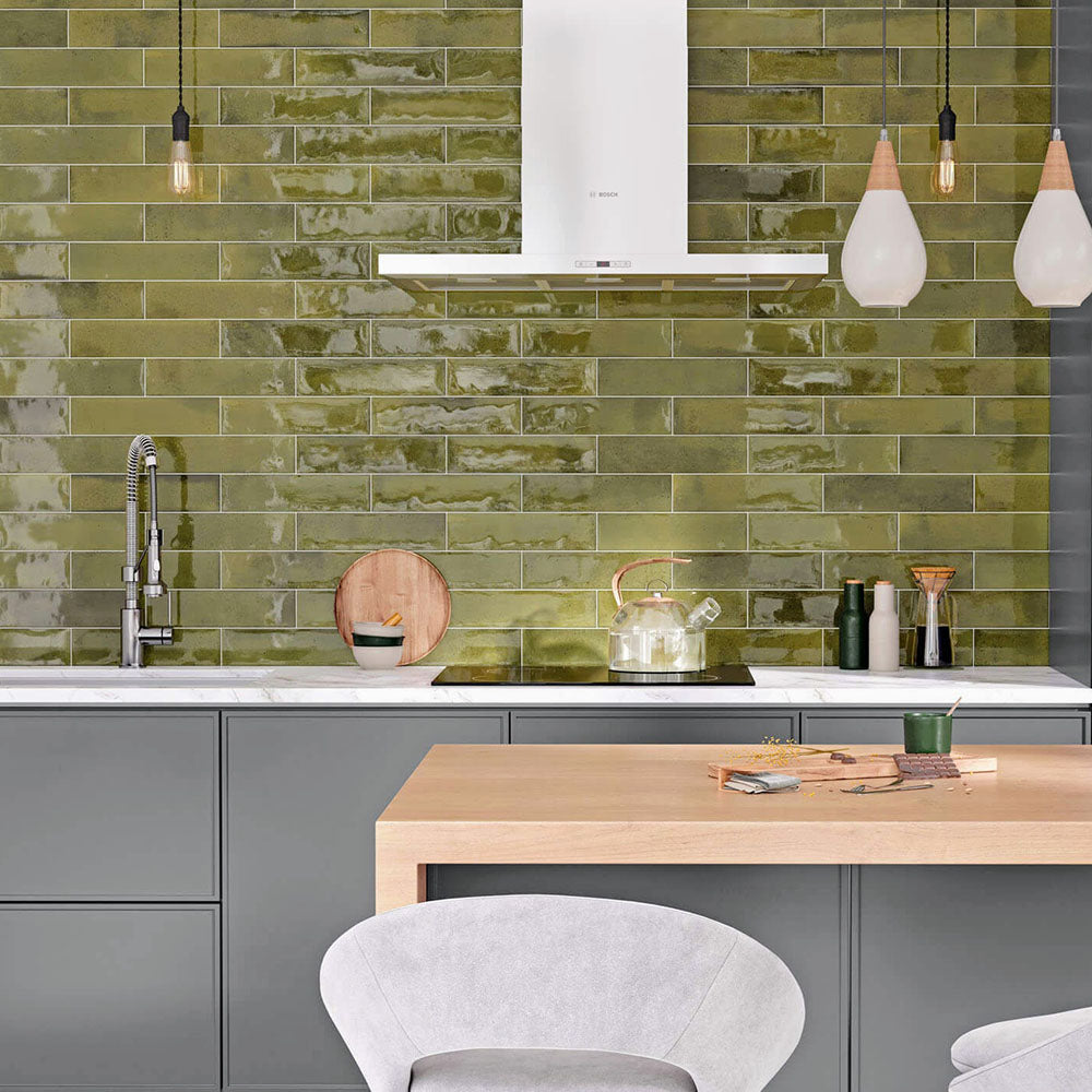 Kitchen splashback featuring Allegra Daisy Green Gloss Brick ceramic tiles in a 6 × 25cm format, creating a vibrant, contemporary look with rich green tones, a glossy finish and subtle handmade-style variation.
