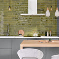 Kitchen splashback featuring Allegra Daisy Green Gloss Brick ceramic tiles in a 6 × 25cm format, creating a vibrant, contemporary look with rich green tones, a glossy finish and subtle handmade-style variation.