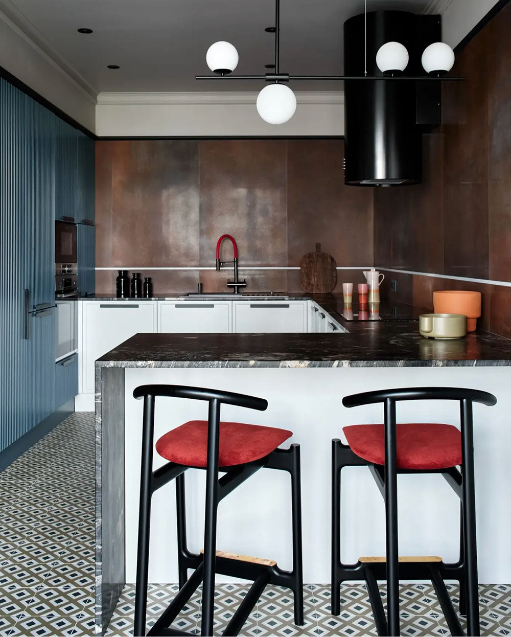 Kitchen setting featuring Viscount Park Road 20x20cm Victorian style wall and floor tiles, showcasing a repeating geometric pattern in soft grey and white tones, paired with rich brown wall tiles, dark worktops and contemporary cabinetry for a bold, design-led finish.