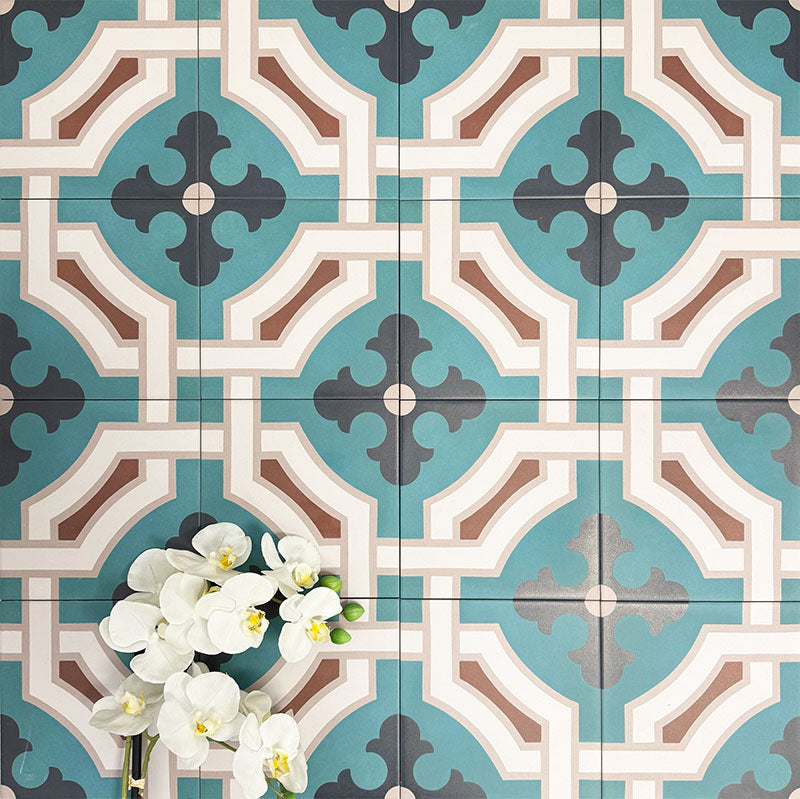 Group of London Streets Leicester Square 20x20cm Victorian Moroccan style porcelain tiles arranged to display the repeating teal, cream and terracotta geometric pattern, styled with white flowers in a decorative flat-lay setting.