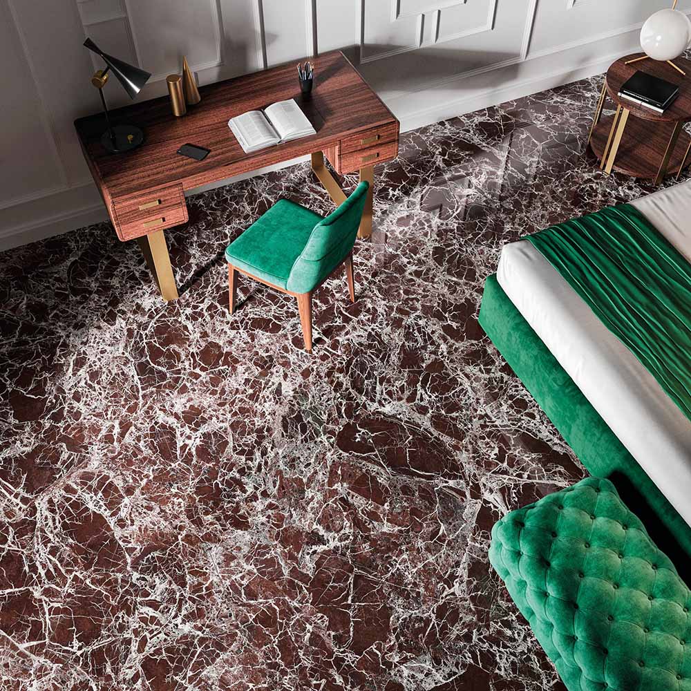 Bedroom interior featuring Levant Rouge Polished Marble effect 60 × 120cm porcelain floor tiles, styled with rich wood furniture, green velvet seating, and dramatic red tones with striking white veining.