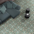Living room interior featuring London Streets Regent Street 20x20cm Victorian Moroccan style floor tiles, styled with a modern sofa, soft cushions and round black side tables, showcasing an elegant green and cream patterned floor.
