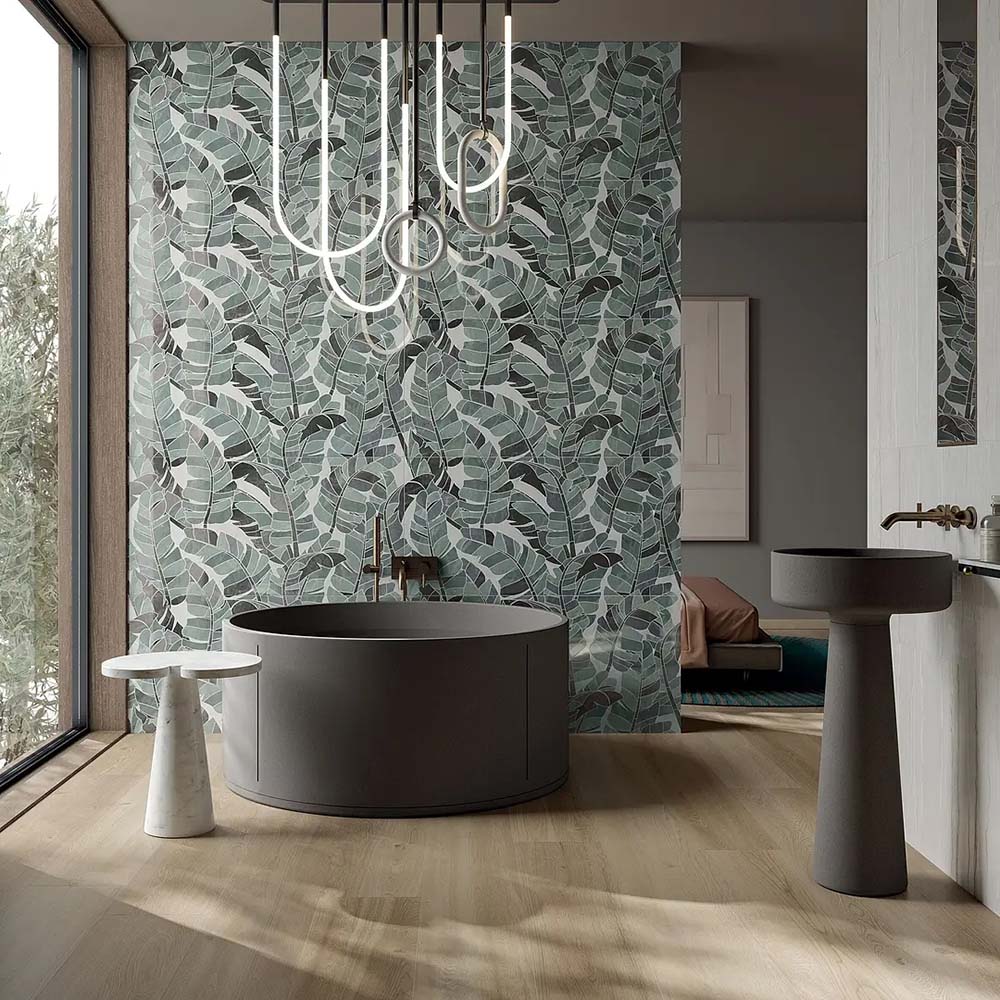 Luxury bathroom featuring Lucca Bali 3D Décor 60 × 120cm porcelain wall tiles, showcasing layered tropical leaf patterns in soft green tones, paired with contemporary black sanitaryware and warm wood finishes.