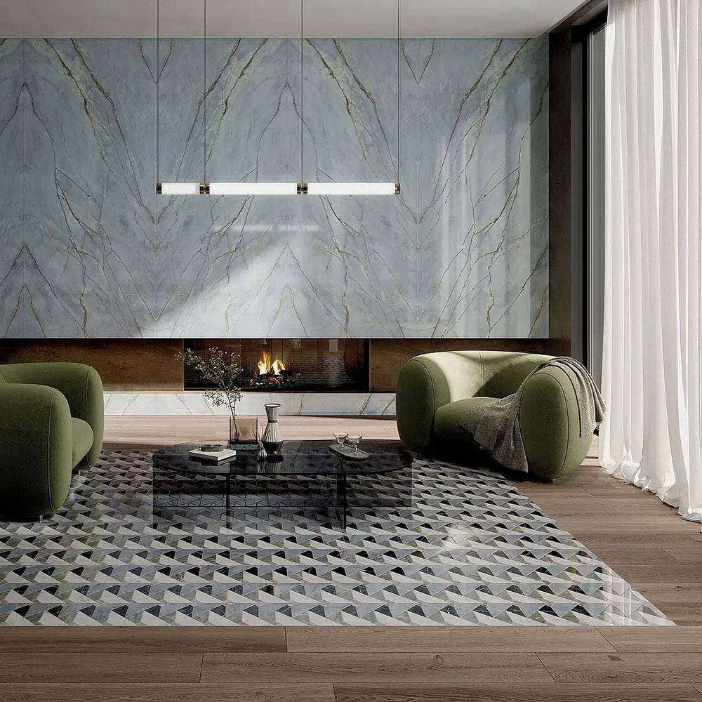 Living room interior featuring Lucca Diamond Tips 3D Décor 60 × 120cm porcelain wall and floor tiles, combining geometric patterned flooring with marble-effect feature walls, styled with olive green lounge chairs, warm wood flooring, and a contemporary fireplace.