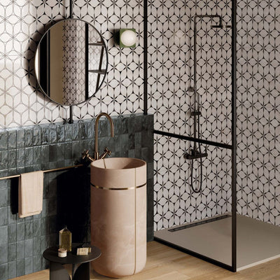 Bathroom interior featuring Lucca Flowers 3D Décor 60 × 120cm porcelain wall and floor tiles, showcasing a repeating floral geometric pattern in soft neutral tones, paired with glossy deep green wall tiles, black shower framing, and warm brass fittings for a contemporary statement finish.