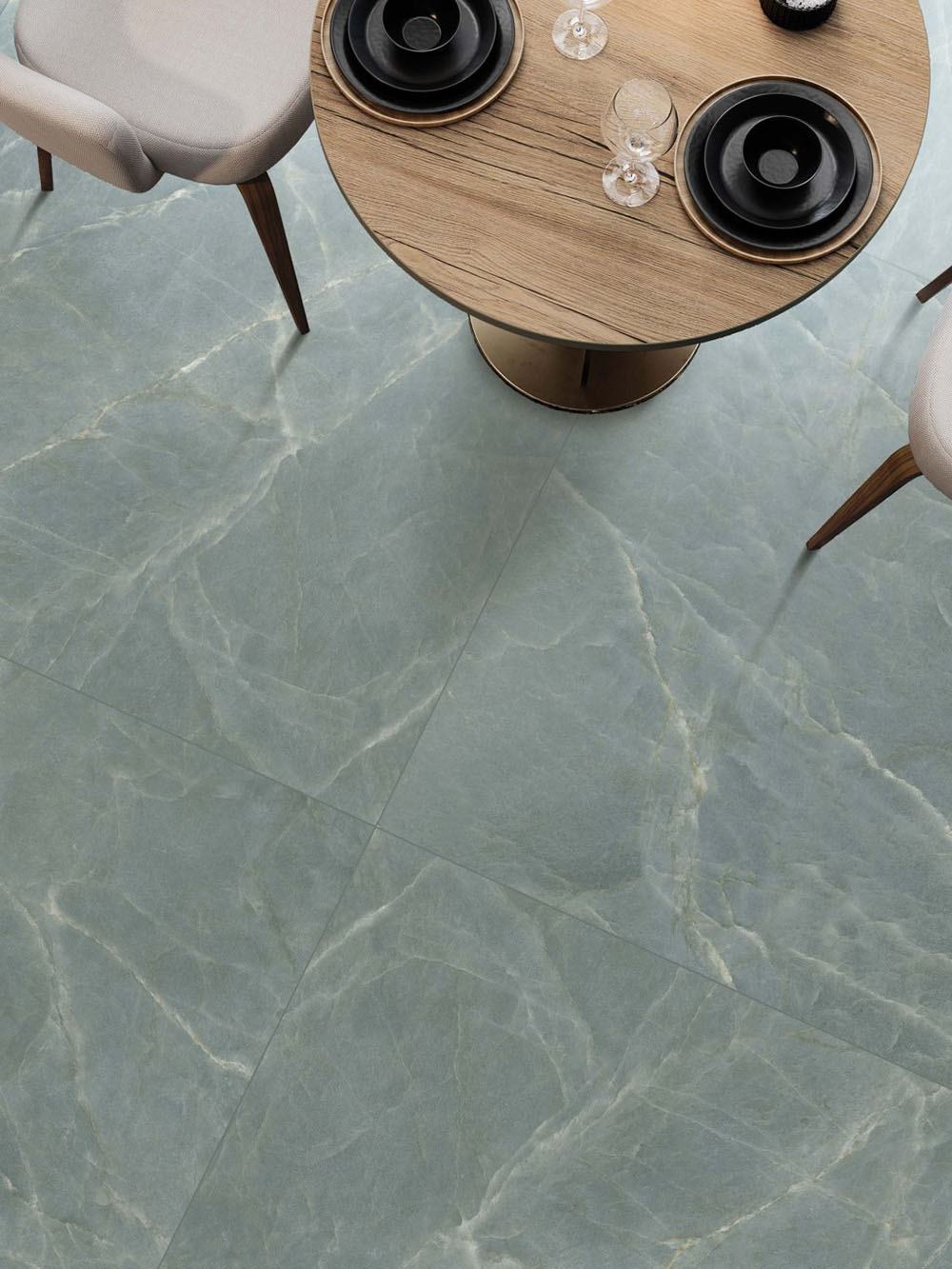 Dining area featuring Lucca Ocean Green Natural Matt 60 × 120cm porcelain floor tiles, showcasing soft green marble-effect tones with delicate veining, paired with contemporary dining furniture and warm natural wood finishes.