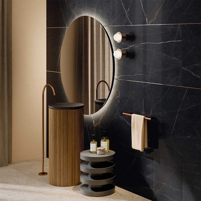 Bathroom interior featuring Lucca Precious Noir Lux 3D 60 × 120cm porcelain wall and floor tiles, showcasing a deep black marble-effect surface with delicate gold veining, paired with warm brass fittings, wood textures, and soft ambient lighting for a luxurious contemporary finish.