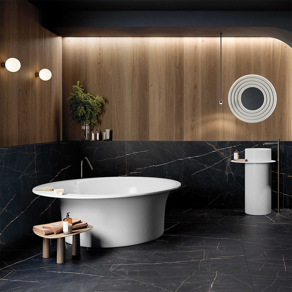 Luxury bathroom interior featuring Lucca Precious Noir Lux 3D 60 × 120cm porcelain wall and floor tiles, showcasing a deep black marble-effect finish with delicate gold veining, styled with warm wood panelling, brass fittings, and a freestanding white bath for a refined contemporary look.