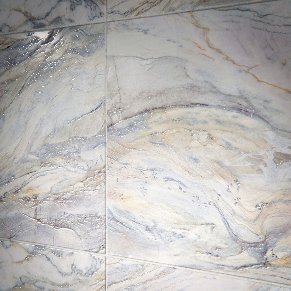 Close-up of Lucca Quartz Lux 3D 60 × 120cm porcelain wall and floor tiles, showcasing flowing marble-effect veining in soft cream, grey, and blue tones with a luxurious polished stone-inspired finish.