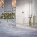 Luxury bathroom featuring Lucca Quartz Matt 60 × 120cm porcelain wall and floor tiles, styled with soft marble-effect veining, green stone vanity details, textured white wall tiles, and elegant contemporary finishes.