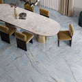 Dining area featuring Lucca River Blue Lux 3D 60 × 120cm porcelain wall and floor tiles, styled with soft blue marble-effect tones, warm veining, velvet dining chairs, and contemporary neutral interiors.