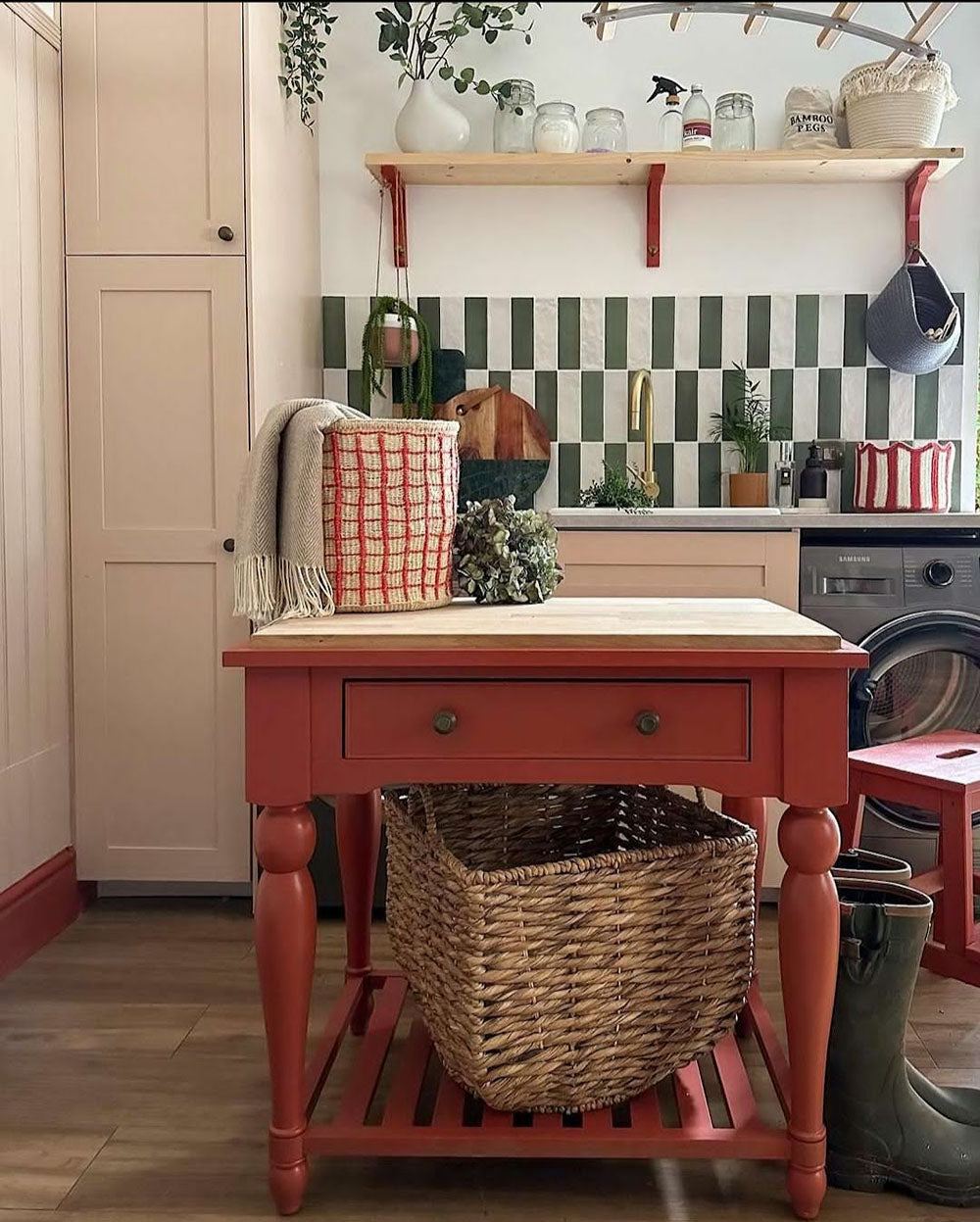 Kitchen interior featuring Zellige Malachite Green and Zellige Oyster 6.5x20cm Moroccan-style brick tiles installed vertically in a striped splashback, styled with brass tap, wooden shelving, and greenery for a warm, contemporary look.