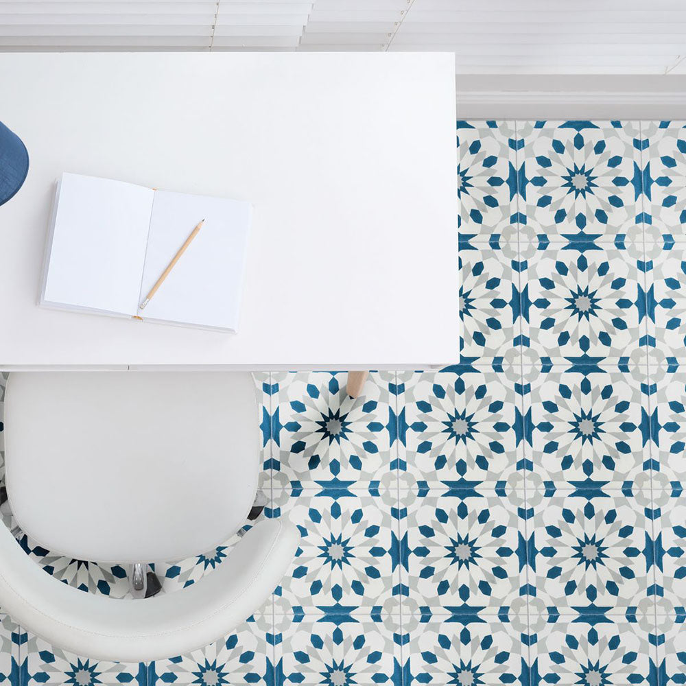 Home office featuring Souk Blue A 20×20cm Moroccan-style porcelain tiles, showcasing a blue and white geometric pattern beneath a white desk and seating.