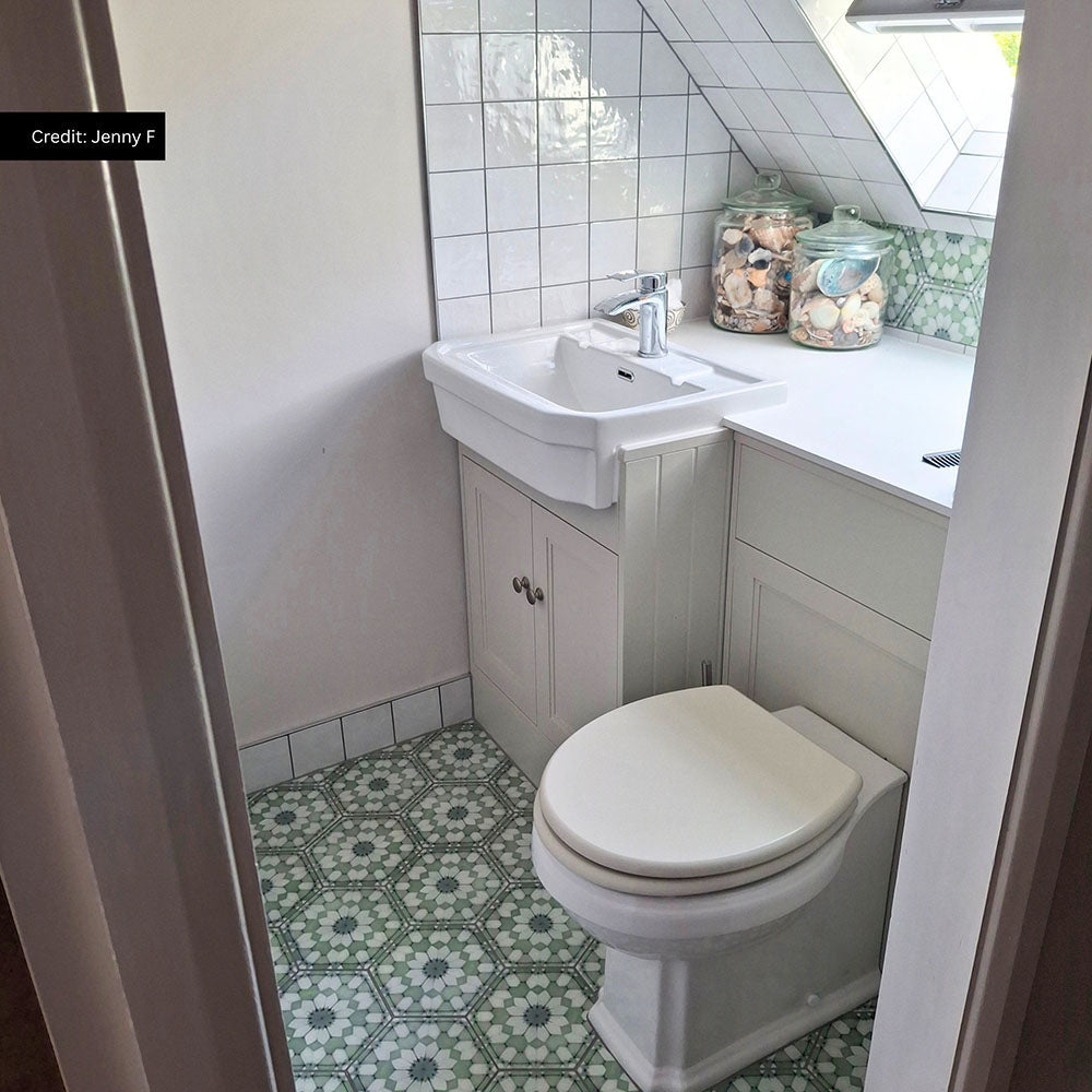 Traditional cloakroom featuring Medina Soft Green Moroccan style hexagon floor tiles, paired with white square wall tiles, a classic white vanity unit, a chrome tap and soft sage green accents for a bright, characterful space.