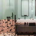 Contemporary bathroom featuring Melody Rock Pink 60cm x 120cm terrazzo effect porcelain wall and floor tiles, paired with mint green fluted wall tiles, black brassware, floating vanity and a walk-in shower.