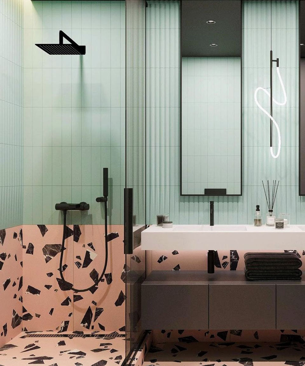 Contemporary bathroom featuring Melody Rock Pink 60cm x 120cm terrazzo effect porcelain wall and floor tiles, paired with mint green fluted wall tiles, black brassware, floating vanity and a walk-in shower.