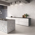 Contemporary kitchen featuring Melody ROCK Terrazzo White 60 × 120cm terrazzo-effect porcelain wall tiles, showcasing oversized white stone fragments on a soft pale base, paired with minimalist cabinetry, concrete finishes, and a statement terrazzo island for a modern architectural look.