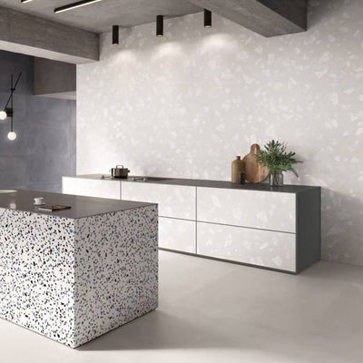 Contemporary kitchen featuring Melody ROCK Terrazzo White 60 × 120cm terrazzo-effect porcelain wall tiles, showcasing oversized white stone fragments on a soft pale base, paired with minimalist cabinetry, concrete finishes, and a statement terrazzo island for a modern architectural look.