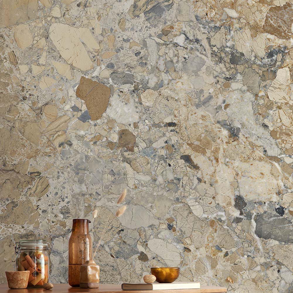 Interior featuring Museo Warm Stone Matt 60x120cm porcelain tiles, showcasing a bold marble effect design with warm beige, ivory and grey stone fragments, styled with natural wood surfaces and contemporary decorative accessories.
