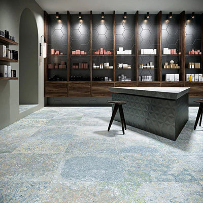 Interior featuring Boho Ocean Blue 60 × 60cm patterned floor tiles, blending soft blue and muted tones with a worn, decorative effect. Ideal for adding character to contemporary spaces such as retail interiors, kitchens, or open-plan living areas.