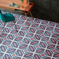 Office interior featuring London Streets Conduit Street 20x20cm Victorian Moroccan style floor tiles, styled with a wooden desk, green chair and dark wall tiles, showcasing a bold pink, teal and white patterned floor design.