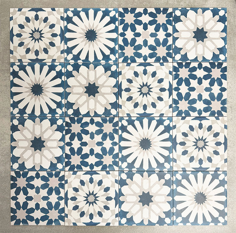 Souk Blue D 20×20cm Moroccan-style porcelain patchwork tiles featuring mixed blue, white and grey geometric patterns.