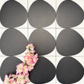 Pebbles Reversed Black 20x20cm porcelain Moroccan-style tiles featuring bold abstract black shapes on a soft white background, designed to create striking statement walls and contemporary patterned interiors.