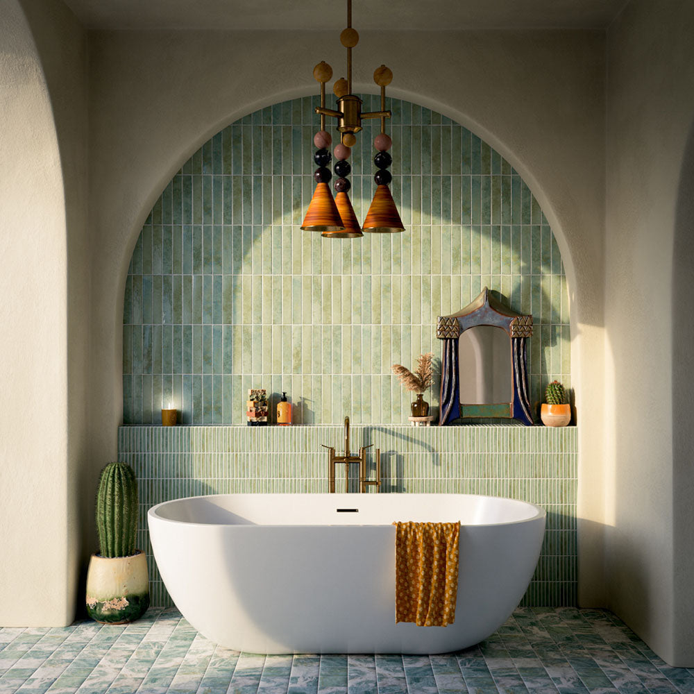 Bathroom featuring Pottery Agave Green 5x25cm glossy brick wall tiles with tonal variation, paired with striped tile detailing and brushed brass fixtures for a warm, spa-inspired contemporary interior.