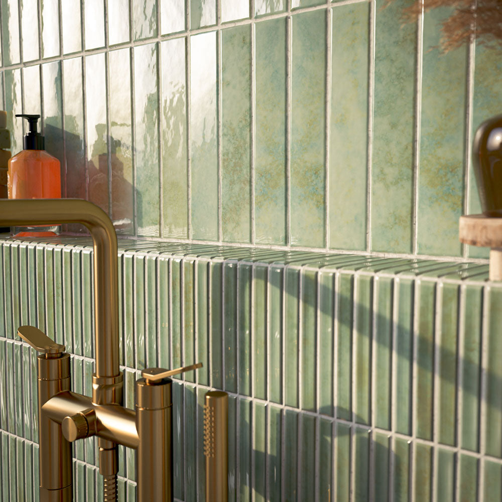Bathroom featuring Pottery Decor Agave Green 12.5x25cm wall tiles, styled within an arched alcove around a freestanding bath with brass fixtures, striped tile detailing, and soft Mediterranean-inspired tones.