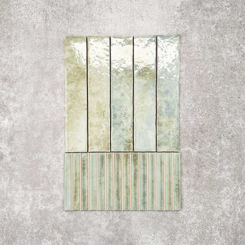 Product display of Pottery Decor Agave Green 12.5x25cm ceramic wall tiles in soft green tones, featuring a handcrafted glossy finish with coordinating fluted decorative tiles for textured contemporary interiors.