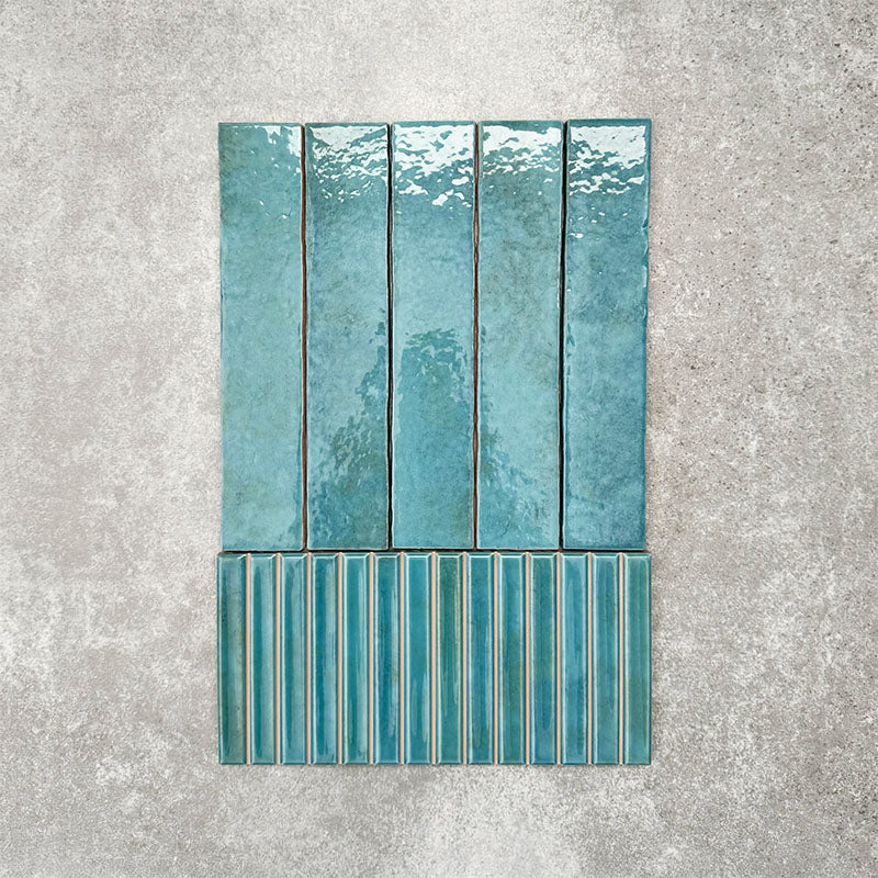 Product display of Pottery Decor Azul Blue 12.5x25cm ceramic wall tiles in vibrant blue tones, featuring a handcrafted glossy finish with coordinating fluted decorative tiles for textured contemporary interiors.