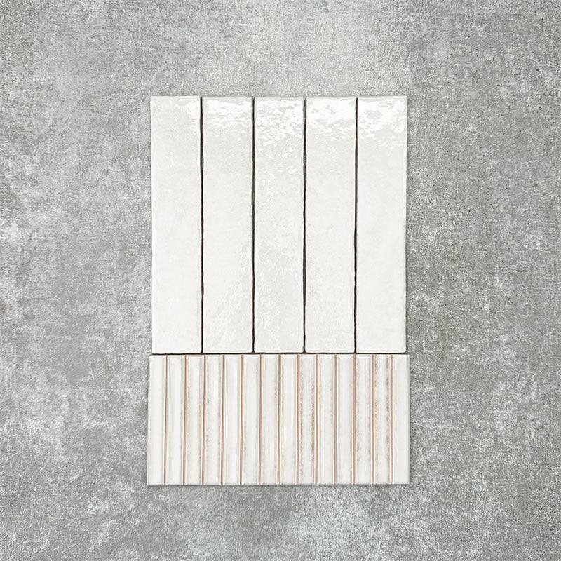 Product display of Pottery Decor Blanco 12.5x25cm ceramic wall tiles in soft white tones, featuring a handcrafted glossy finish with coordinating fluted decorative tiles for textured contemporary interiors.