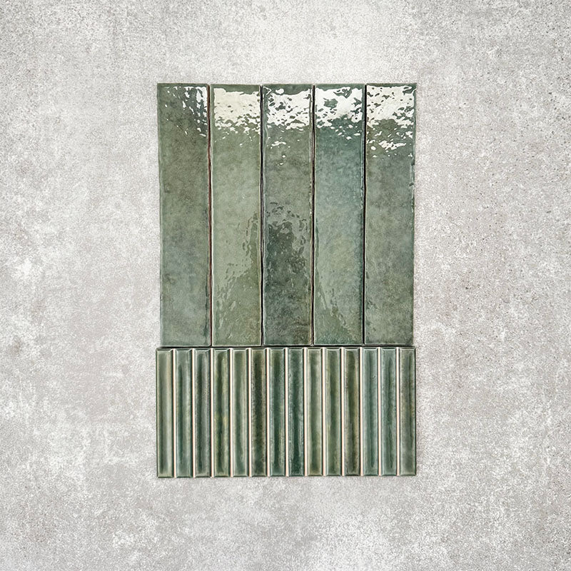 Product display of Pottery Decor Forest Green 12.5x25cm ceramic wall tiles in deep green tones, featuring a handcrafted glossy finish with coordinating fluted decorative tiles for textured contemporary interiors.