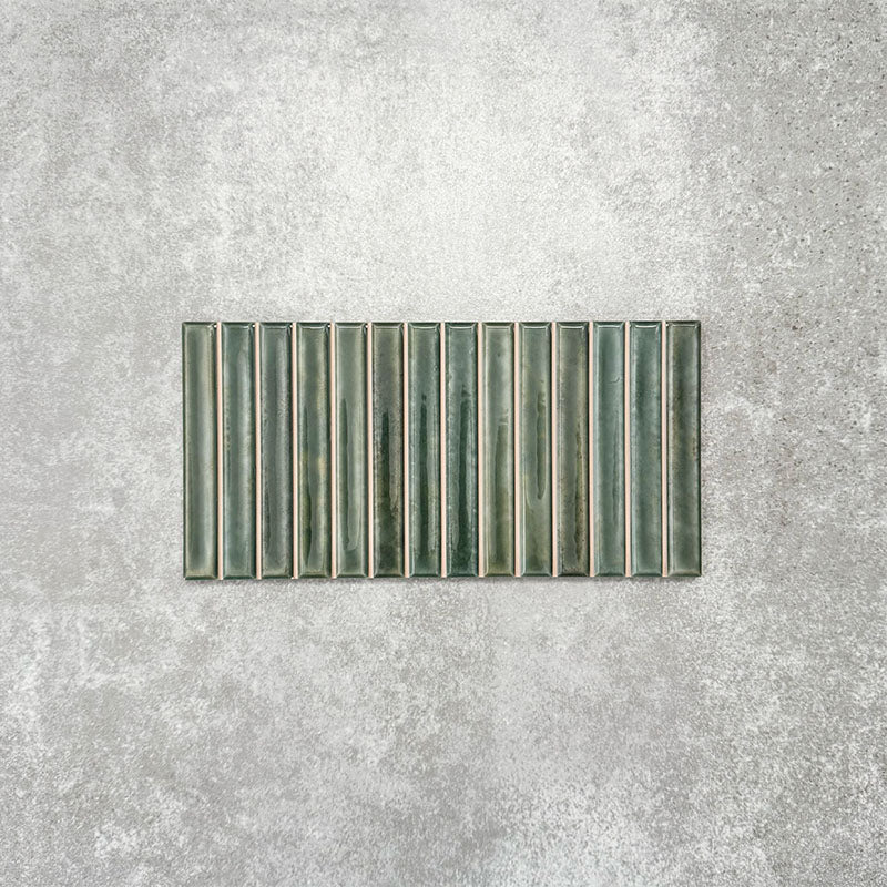 Product display of Pottery Decor Forest Green 12.5x25cm ceramic wall tiles in deep green tones, featuring a linear fluted design, handcrafted glossy finish and subtle tonal variation for textured contemporary interiors.