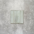 Product image of Puzzle Breeze Green Brick Rectified 5x20cm wall and floor tiles, featuring a glossy pale green finish with subtle tonal variation and softly aged edges, displayed to highlight the tile's handcrafted character.