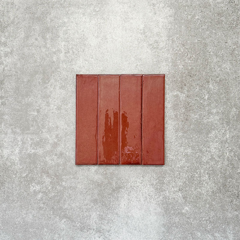 Product image of Puzzle Coral Brick Rectified 5x20cm wall and floor tiles, featuring a glossy coral finish with rich tonal variation and softly aged edges, displayed to highlight the tile's handcrafted character.