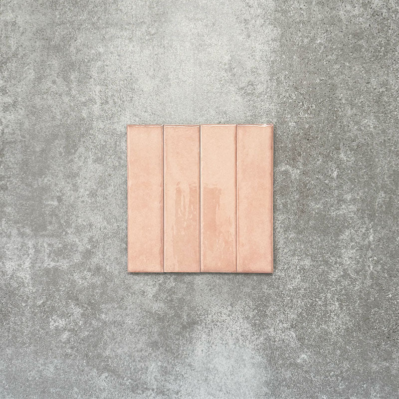 Product image of Puzzle Rose Brick Rectified 5x20cm wall and floor tiles, featuring a glossy blush pink finish with soft tonal variation and gently aged edges, displayed to highlight the tile's handcrafted character.