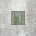 Product image of Puzzle Sage Green Brick Rectified 5x20cm wall and floor tiles, featuring a glossy sage green finish with subtle tonal variation and softly aged edges, displayed to highlight the tile's handcrafted character.