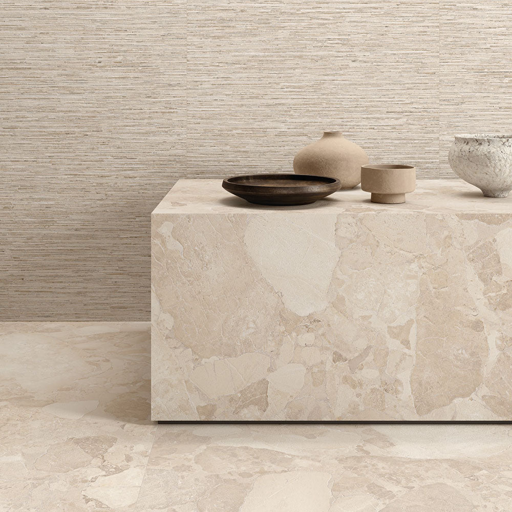 Interior featuring Riad Avorio Sassi Terrazzo Stone 60x60cm stone-effect wall and floor tiles, showcasing warm ivory and beige tones with natural stone-inspired detailing, styled with matching tiled cabinetry and light wood shelving for a contemporary finish.