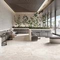 Contemporary lounge featuring Riad Blanco Sassi Terrazzo Stone 60x120cm stone-effect floor tiles, showcasing soft cream and beige tones with natural stone-inspired detailing, paired with minimalist seating, indoor planting and floor-to-ceiling glazing.