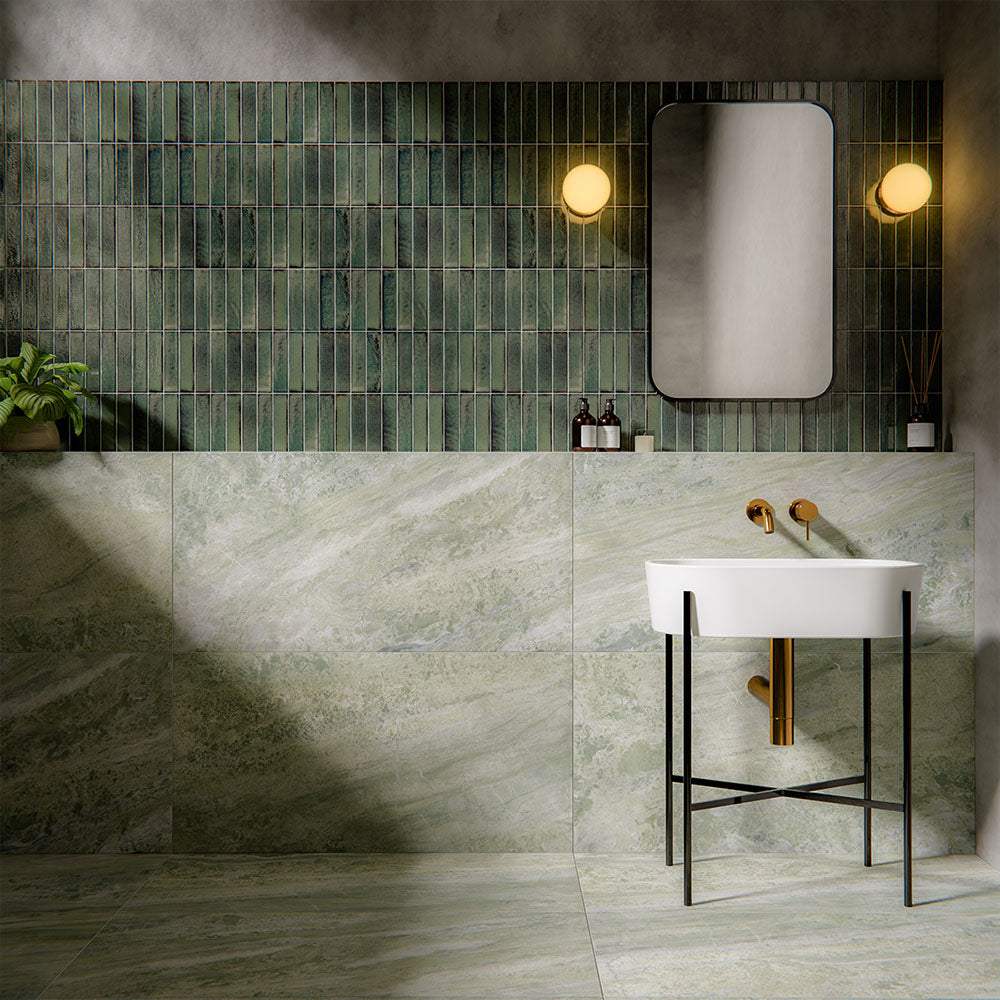 Bathroom interior featuring Petra Verde Green Stone marble style 60x120cm tiles, installed across walls and floor, showcasing soft green veining and natural stone-inspired movement, styled with brass fittings and modern basin.