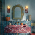 Bathroom setting featuring Foundry Bricks Marine Blue 6.5x20cm wall tiles, showcasing rich blue tones with subtle tonal variation, installed in a vertical layout across the walls, paired with terrazzo effect floor tiles, a statement red marble basin and brass fittings for a bold, design-led contrast.