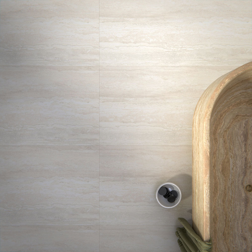 Bathroom interior featuring Trevi Stone 60 x 120cm porcelain floor tiles in a soft matt finish, showcasing a subtle natural stone effect in warm neutral tones, paired with a statement freestanding bath and patterned wall tiles to create a calm, balanced space.
