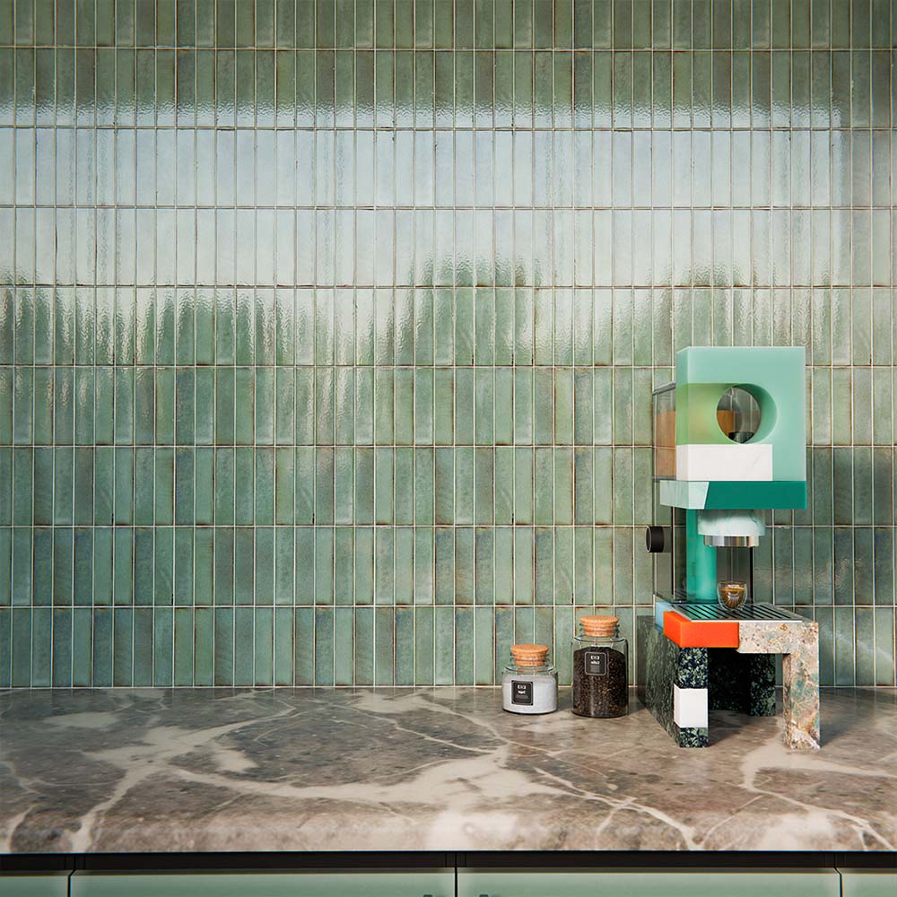 Puzzle Sage Green Brick Rectified 5x20cm porcelain tiles used as a full-height kitchen splashback, showcasing soft sage green tones with subtle speckling and natural shade variation. The slim brick format enhances vertical lines and texture, pairing beautifully with matching cabinetry, warm wood finishes and brass accents for a cohesive, contemporary kitchen design.