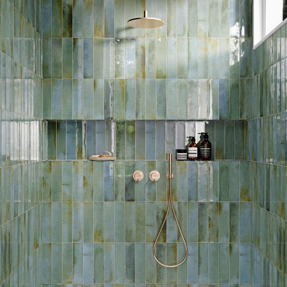 Shower walls tiled with Allegra Celadon Green Gloss Brick ceramic tiles in a 6 × 25cm format, creating a spa-like feel with soft green tones, a glossy finish and subtle handmade-style variation.